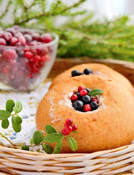 Teller hausgemachte Brötchen mit Beeren, serviert auf altem Holztisch — Stockfoto