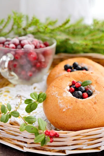 Teller hausgemachte Brötchen mit Beeren, serviert auf altem Holztisch — Stockfoto