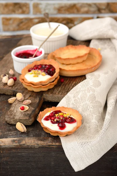 Tartlets with cream, berry sauce and pistachios — Stock Photo, Image