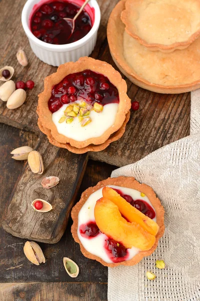 Tartlets with cream, berry sauce and pistachios — Stock Photo, Image