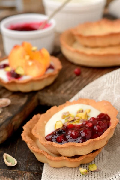 Tartlets met cream, berry saus en pimpernoten (pistaches) — Stockfoto
