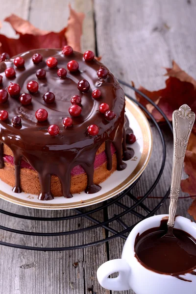 Torta di biscotti fatta in casa con mousse di mirtilli rossi e glassa al cioccolato su fondo di legno — Foto Stock