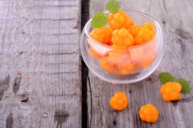 ahşap arka plan üzerinde organik taze Kuzey cloudberries