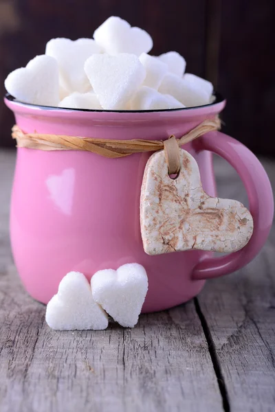 Tasse rose avec des coeurs de sucre — Photo