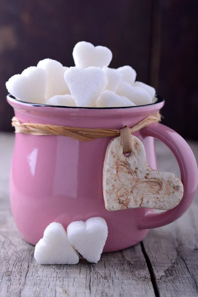 Розовая кружка с сахарными сердцами — стоковое фото