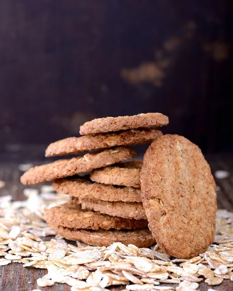 Tenké ovesných vloček sušenky na staré dřevěné pozadí — Stock fotografie