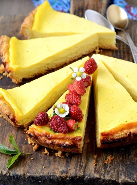 Slices of fresh homemade cheesecake with berries on old wooden background — Stock Photo, Image