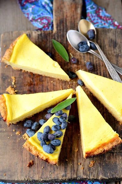 Slices of fresh homemade cheesecake with berries on old wooden background — Stock Photo, Image