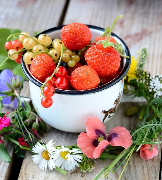 Mug  with fresh berries on black stone background — Stock Photo, Image