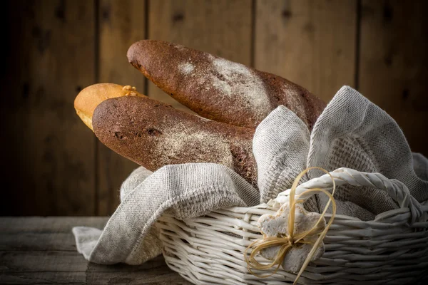 Bröd, bullar croissanter i en korg — Stockfoto