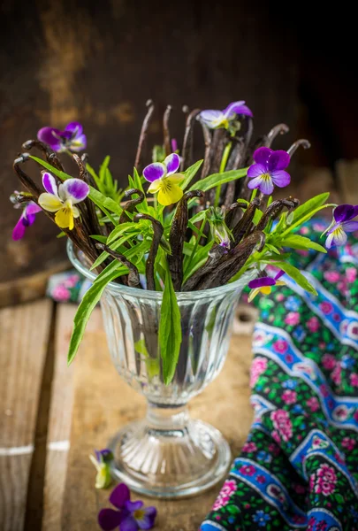 Ramo de flores con vaina de vainilla en vidrio vintage — Foto de Stock