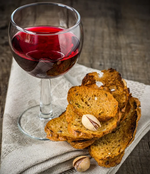 Copa de vino tinto con nueces y galletas —  Fotos de Stock