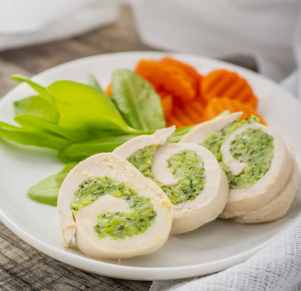 Rolos de peitos de frango e legumes no prato — Fotografia de Stock