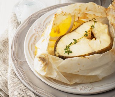 Parşömen kağıt limon dilimleri ile pişmiş morina fileto