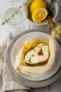 Parşömen kağıt limon dilimleri ile pişmiş morina fileto