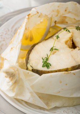 Parşömen kağıt limon dilimleri ile pişmiş morina fileto