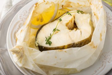 Parşömen kağıt limon dilimleri ile pişmiş morina fileto
