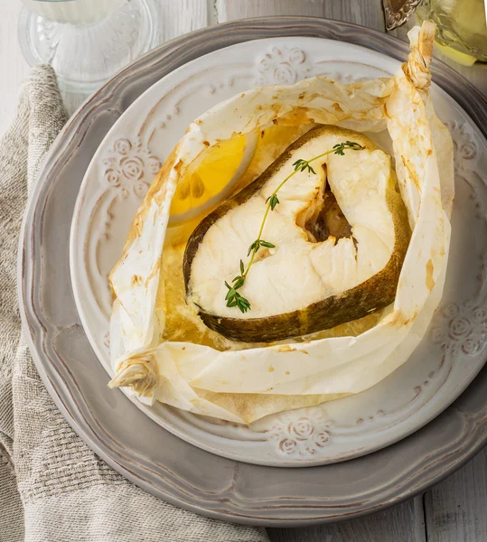 Cod fillets  baked in parchment paper with slices of lemon — Stock Photo, Image