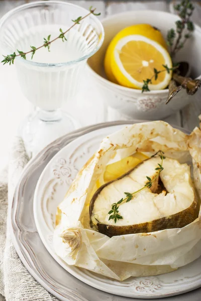 Filetes de bacalhau assados em pergaminho com fatias de limão — Fotografia de Stock