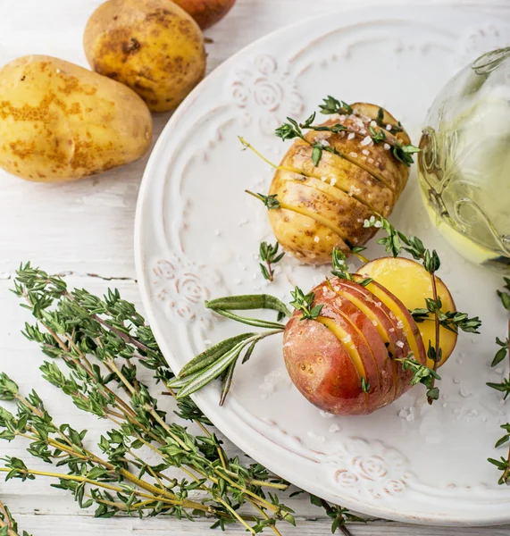 Gesneden ruwe aardappelen met takjes tijm, zeezout en boter voor het bakken Stockafbeelding