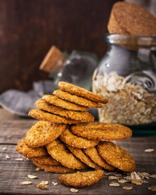 İnce yulaf ezmesi kurabiye kraker ahşap koyu arka plan üzerinde