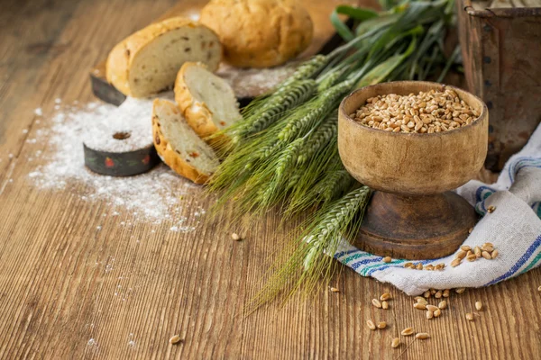 Ears of barley flour, bread on a wooden background — ストック写真