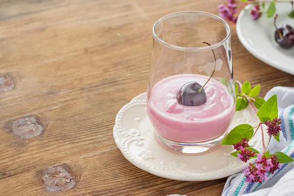 Вишневый йогурт и спелые вишни с веточкой майорана — стоковое фото