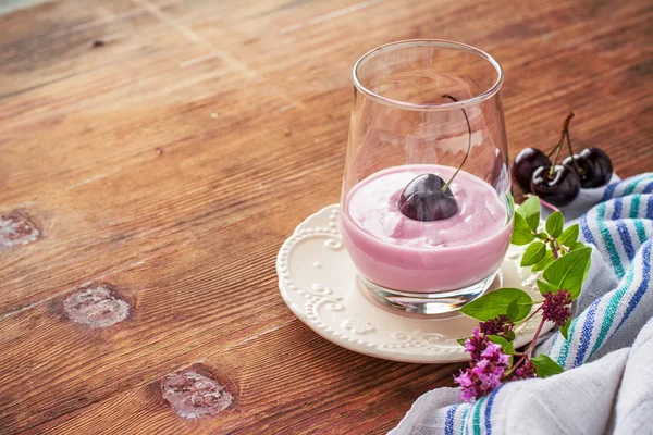 Cherry yogurt and ripe cherry with a sprig of marjoram — Stockfoto