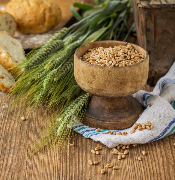 Orecchie di orzo e grano sullo sfondo di legno — Foto Stock