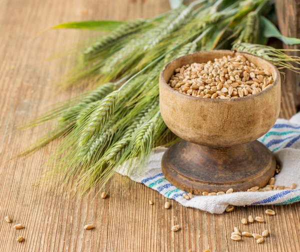 Ears of barley and wheat on the wooden background — 图库照片