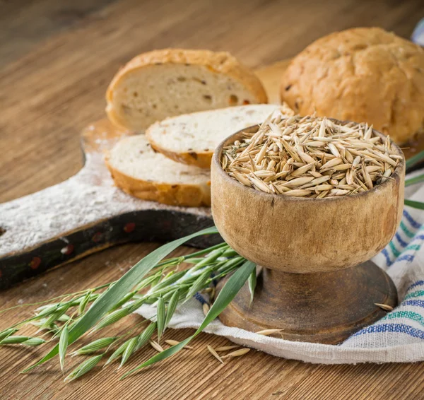 Oat flour, grain oats, oat bread on wooden background with home lyanm textiles — Zdjęcie stockowe