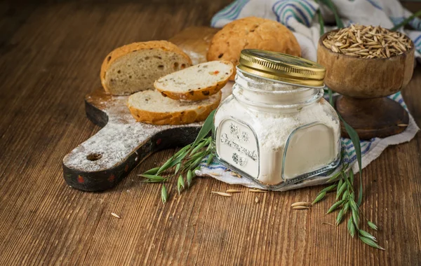 Oat flour, grain oats, oat bread on wooden background with home lyanm textiles — Stok fotoğraf