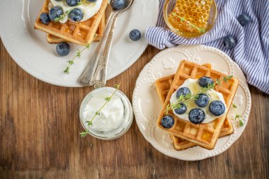 Homemade fresh crispy waffles for breakfast with blueberries and honey