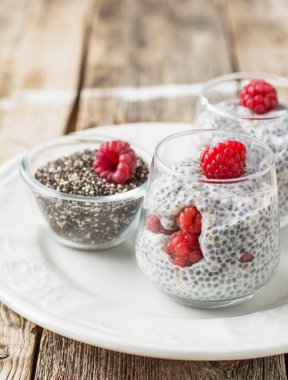 Milk pudding with chia seeds and fresh berries for breakfast in portion jars