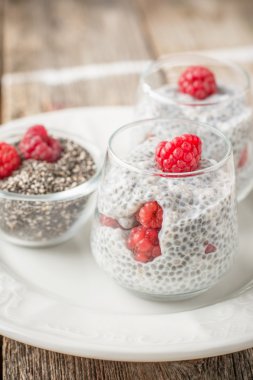 Milk pudding with chia seeds and fresh berries for breakfast in portion jars