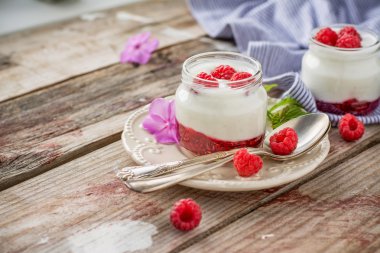Natural yogurt with fresh raspberries and raspberry jam for breakfast in portion jars 