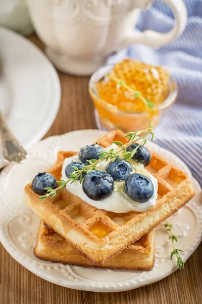 Homemade fresh crispy waffles for breakfast with blueberries and honey — ストック写真