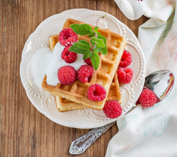 Crispy wafers with cream and fresh raspberries for breakfast