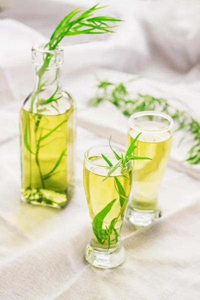 Bright summer drink tarragon in glass bottles and glasses — Stock Photo, Image