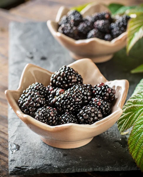 Seramik bardak el yapımı çanak çömlek içinde taze olgun böğürtlen kahvaltıda servis edilir