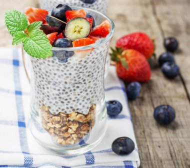 Kahvaltı için kavanozda çilek, yaban mersini, yulaf ezmesi ve chia tohum puding