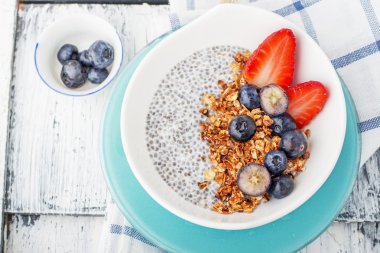 Chia tohum puding yaban mersini, çilek ve ahşap bir zemin üzerine nane ile yaptı. Seçici odak. 