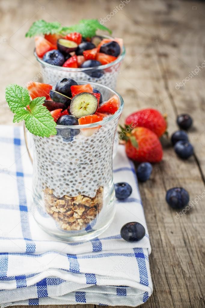 Strawberry, blueberries, oatmeal and chia seeds pudding in a jar for breakfast
