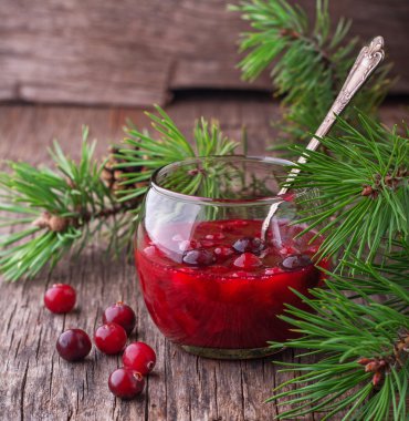 Koyu ahşap zemin üzerine bir bardak taze ev yapımı kızılcık sosu