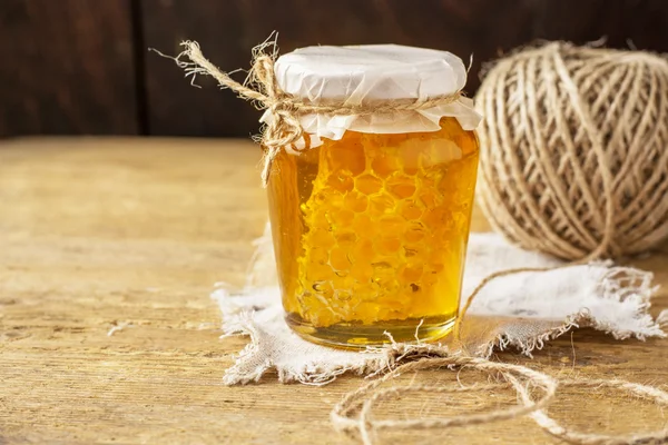 Mel floral fresco com favo de mel em um copo pequeno — Fotografia de Stock