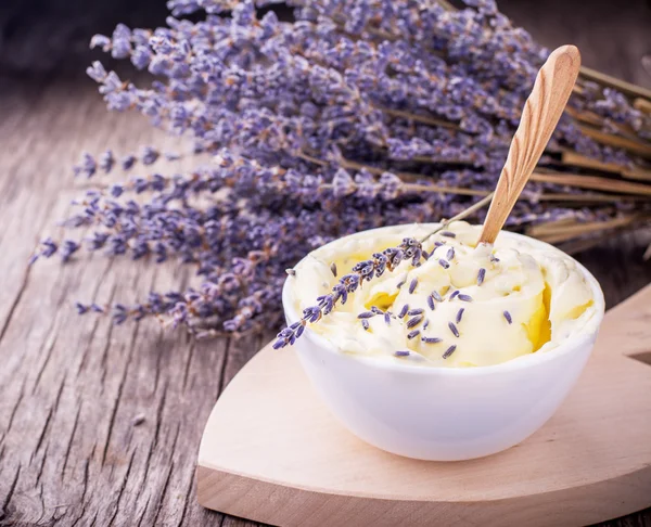 Manteiga de ervas para o café da manhã com flores de lavanda em uma xícara de cerâmica branca — Fotografia de Stock