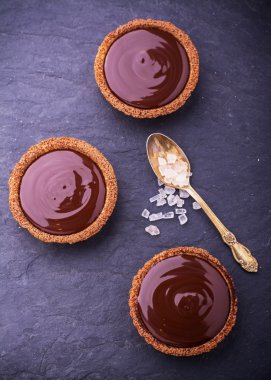 Homemade tarts of shortcrust pastry with dark chocolate and pink crystals sea salt