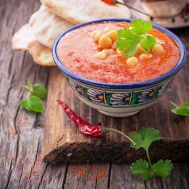 Cream soup puree of roasted tomatoes and peppers served with chickpeas cilantro