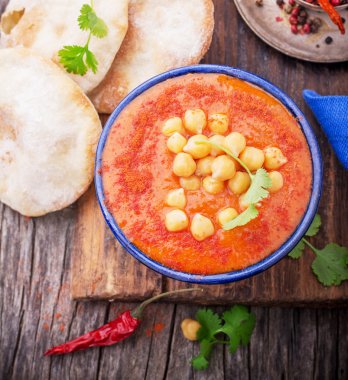 Cream soup puree of roasted tomatoes and peppers served with chickpeas cilantro