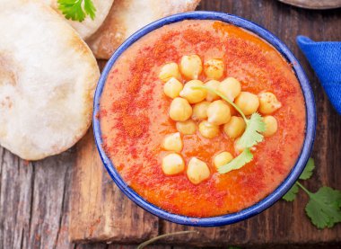 Cream soup puree of roasted tomatoes and peppers served with chickpeas cilantro